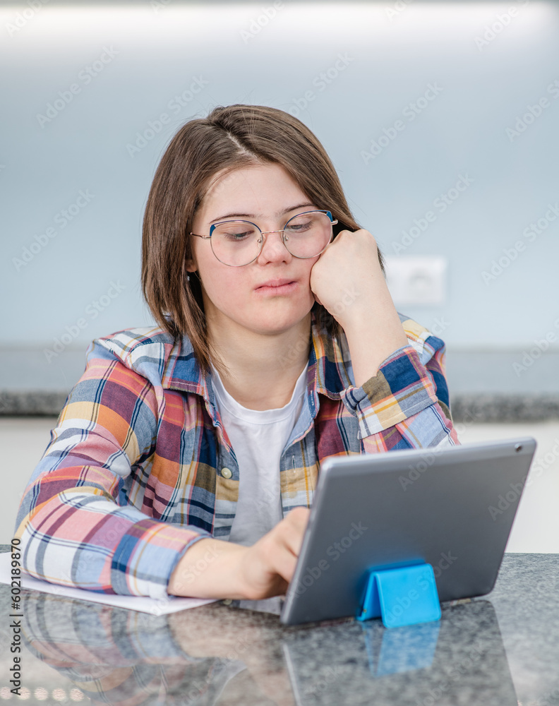 Young girl with Downs syndrome using tablet computer at home Young girl with Downs syndrome using tablet computer at home
