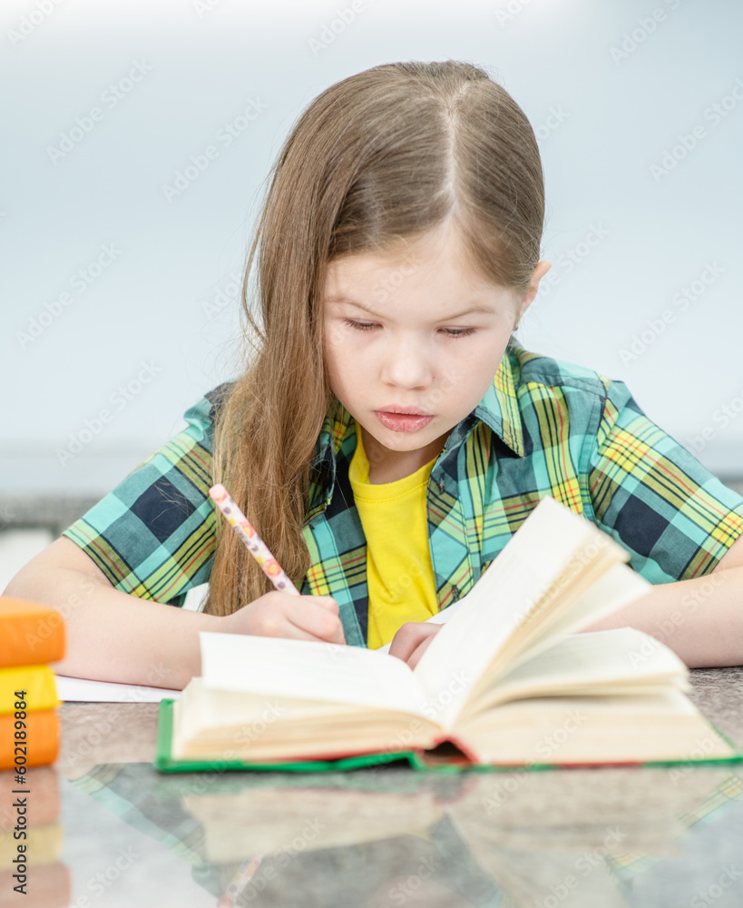 Young little girl doing homework at home with books Young little girl doing homework at home with books