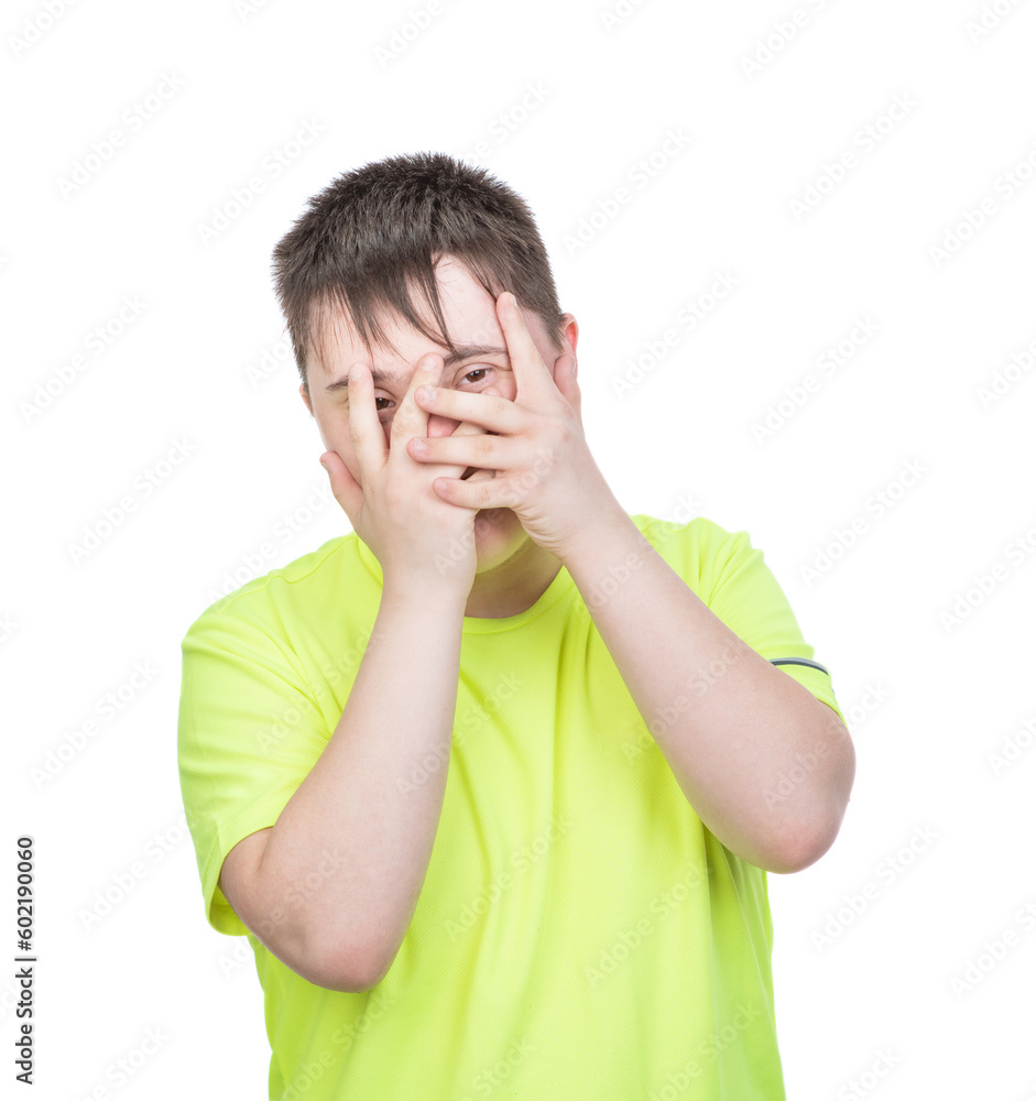 Teen boy with Downs syndrom hiding eyes under hand while feeling ashamed, covering face with palms. Isolated on white background Teen boy with Downs syndrom hiding eyes under hand while feeling ashamed, covering face with palms. Isolated on white background