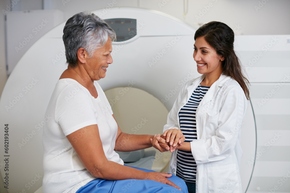 Obraz premium Doctor, ct scan and woman holding hands of patient in hospital before scanning in machine. Mri, comfort and happy medical professional with senior female person before radiology test for healthcare.