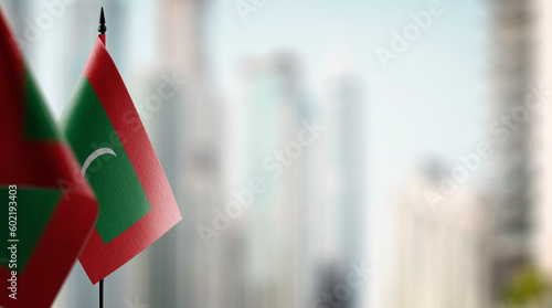 Small flags of the Maldives on an abstract blurry background