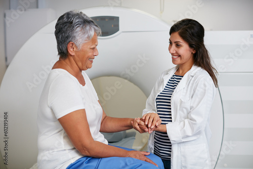 Doctor, ct scan and woman holding hands of patient in hospital before scanning in machine. Mri, comfort and happy medical professional with senior female person before radiology test for healthcare.