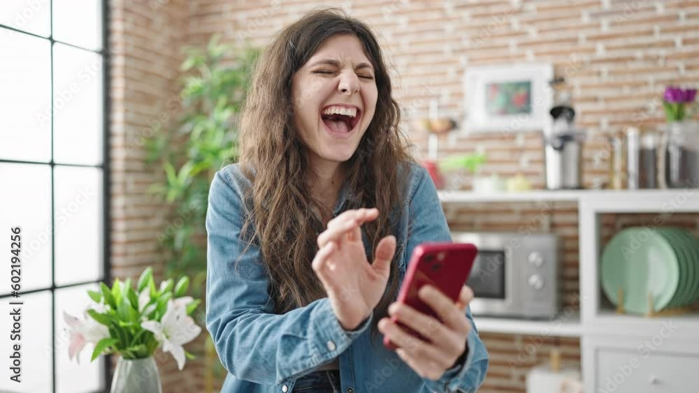 Young beautiful hispanic woman using smartphone sitting on table at dinning room Young beautiful hispanic woman using smartphone sitting on table at dinning room