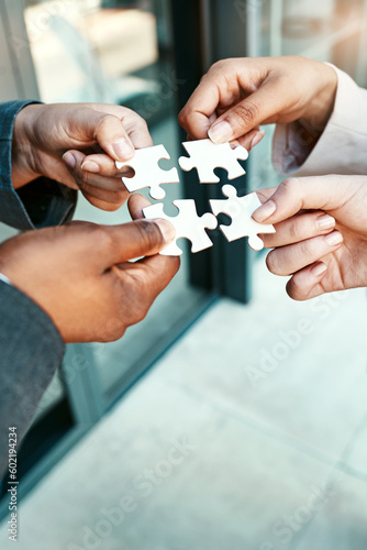 Closeup, hands and puzzle with collaboration, group and teamwork with partnership, planning and brainstorming. Zoom, staff and team with ideas, jigsaw pieces and cooperation with support and solution