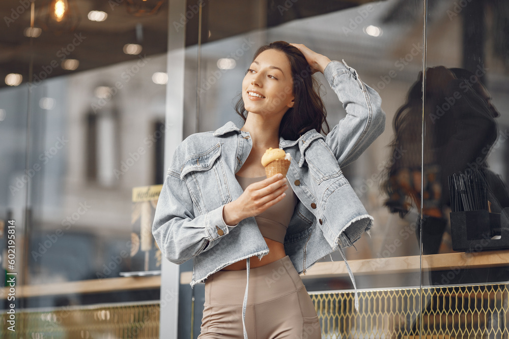 Woman standing in a summer city with ice cream Woman standing in a summer city with ice cream