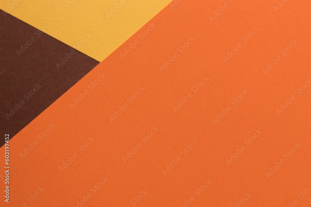 Orange and brown paper lies on the table, creating a geometric composition Orange and brown paper lies on the table, creating a geometric composition
