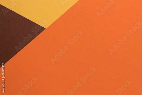 Orange and brown paper lies on the table, creating a geometric composition