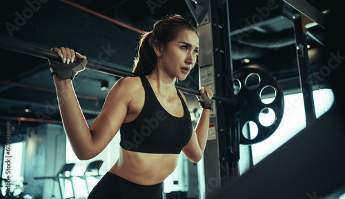 Foto Sporty woman exercising with weight plate in the gym.
