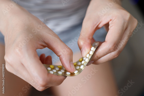 Woman hands opening birth control pills in hand. eating Contraceptive pill. Contraception reduces childbirth and pregnancy concept. photo