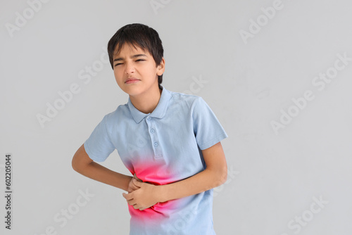 Little boy suffering from appendicitis on light background photo