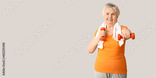 Elderly woman with dumbbell...