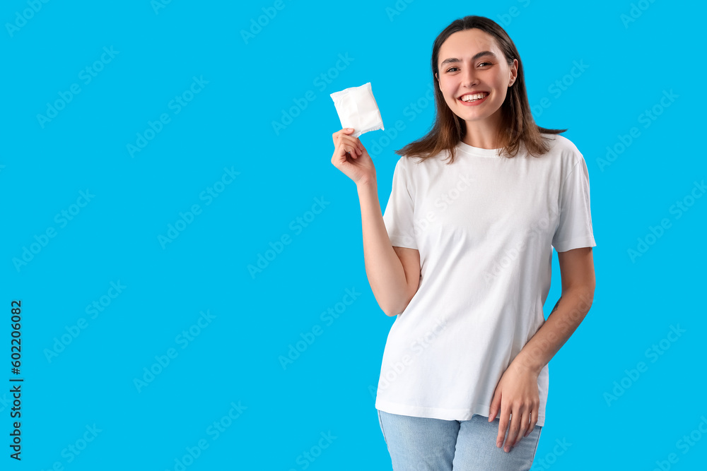 Young woman with menstrual pad on blue background Young woman with menstrual pad on blue background