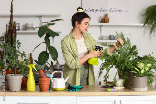 Young woman spraying green ...