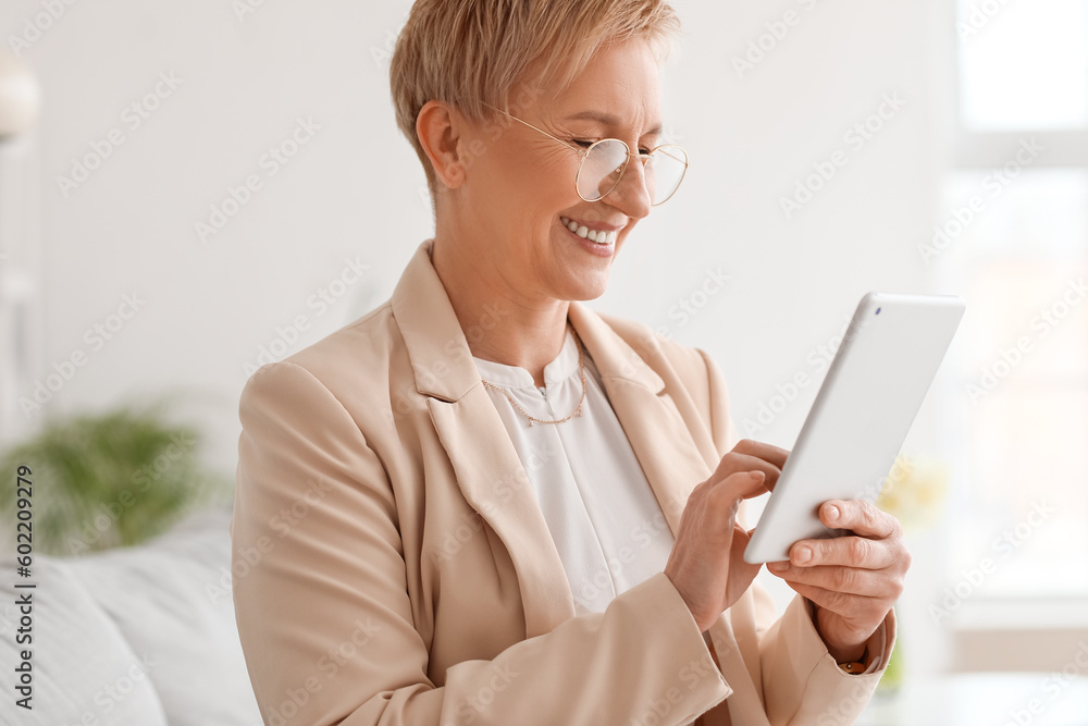 Mature psychologist working with tablet computer in office, closeup
