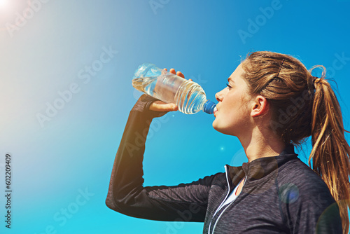 Fotografia Woman drinking water, health and fitness with blue sky, athlete outdoor with hydration and mockup space