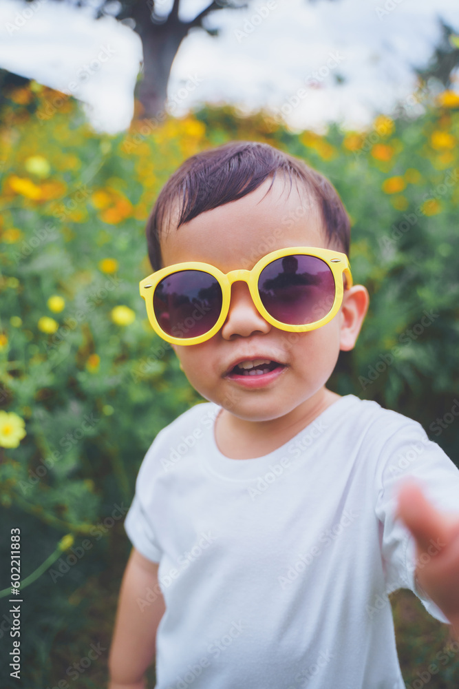 Portrait of Happy smiling Asian Japanese little child boy wearing yellow sunglasses outdoor. looking at camera. Portrait of Happy smiling Asian Japanese little child boy wearing yellow sunglasses outdoor. looking at camera.