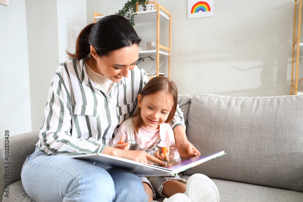 Young woman reading story to her little daughter at home Young woman reading story to her little daughter at home