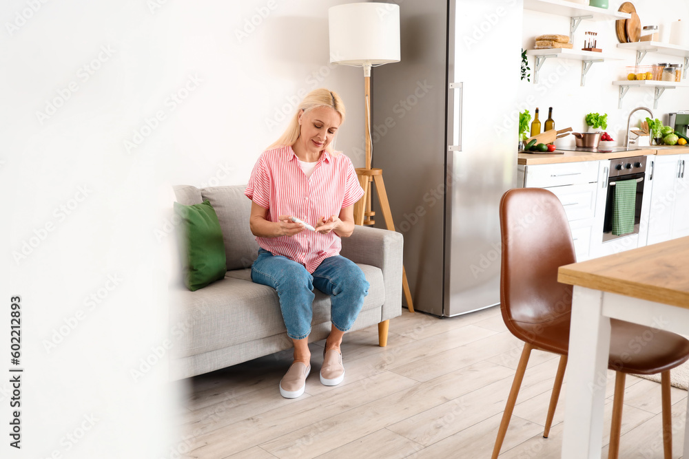 Mature diabetic woman measuring blood sugar level with lancet pen at home Mature diabetic woman measuring blood sugar level with lancet pen at home