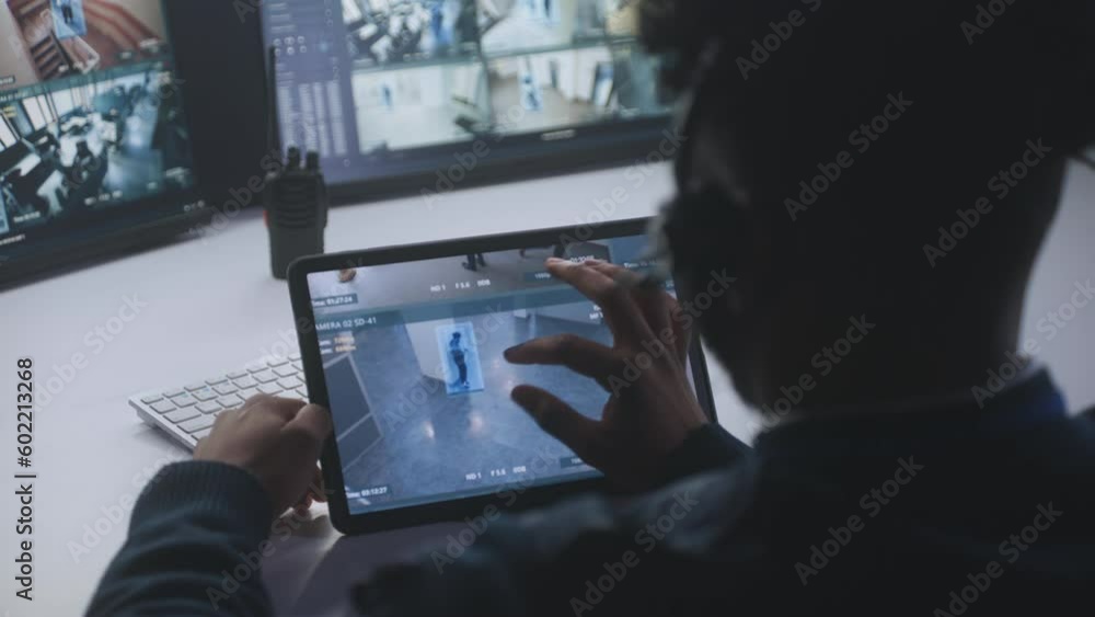 Male operator monitors CCTV cameras. African American man uses digital