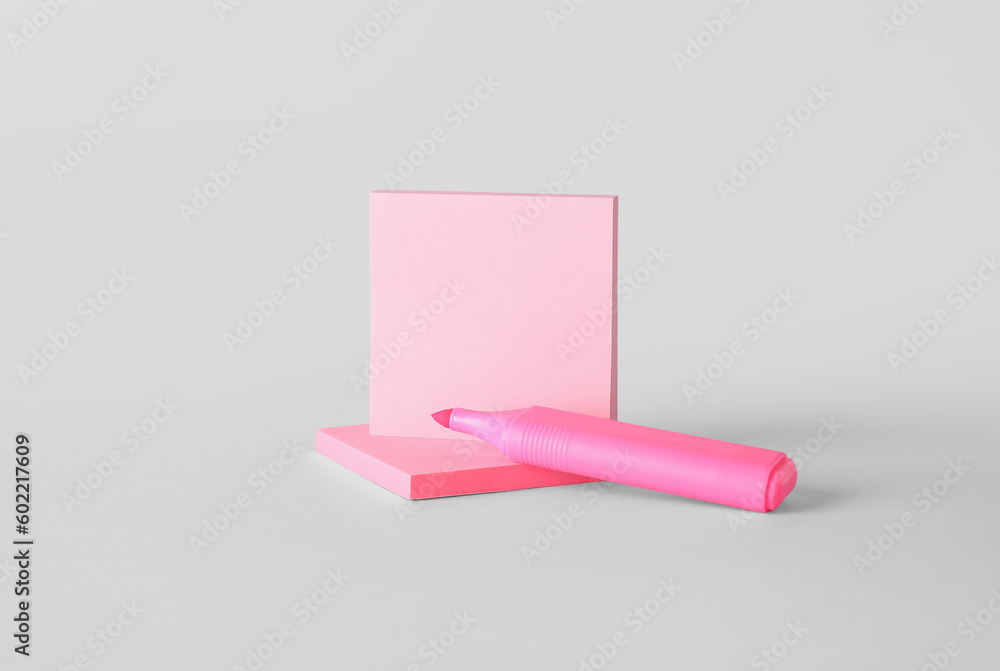 Pink sticky notes with marker on grey background Pink sticky notes with marker on grey background