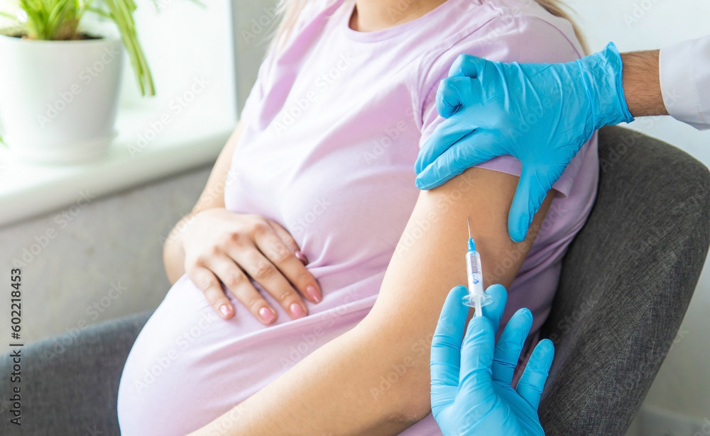 A pregnant woman makes a vaccination. Selective focus. A pregnant woman makes a vaccination. Selective focus.