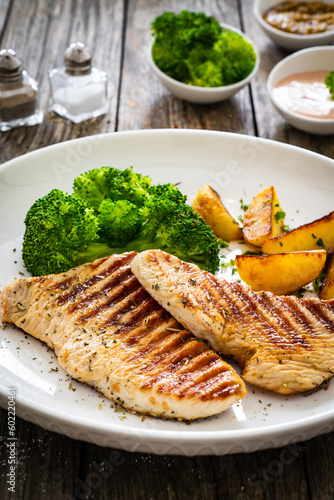 Barbecued turkey breast and broccoli on wooden table 