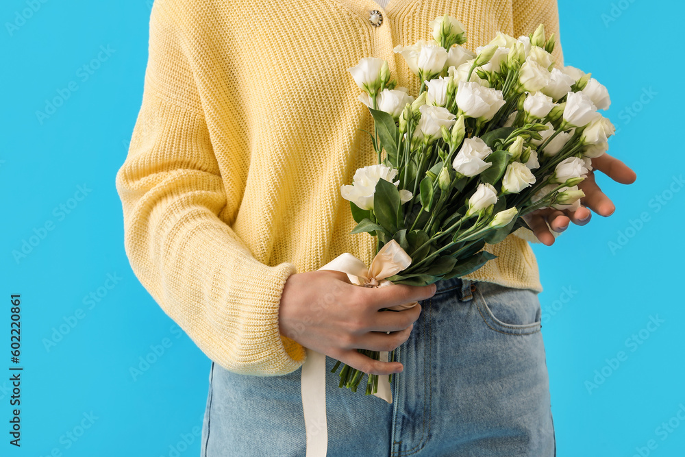 Young woman with bouquet of beautiful eustoma flowers on blue background - obrazy, fototapety, plakaty 