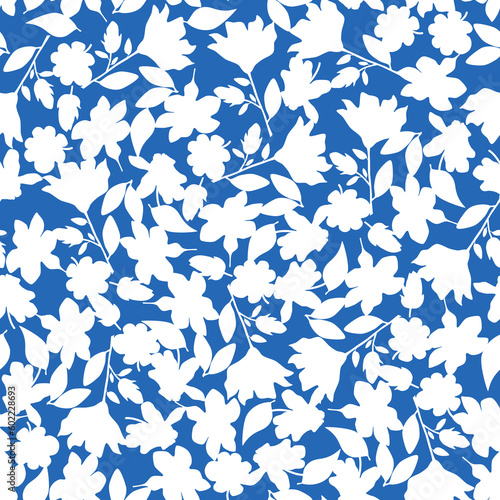 Silhouettes of flowers seamless pattern. White tiny flowers on blue background. Delicate allover floral pattern great for silk clothes design, wrapping, wallpaper