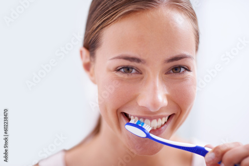Woman, portrait and brushing teeth in bathroom with smile, health and self care for oral hygiene, wellness and routine. Girl, toothbrush and happiness for cleaning, healthy mouth and start morning