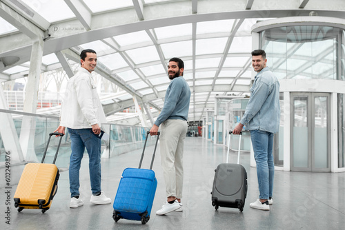 Three Happy Passengers Men With Travel Suitcases Posing In Airport