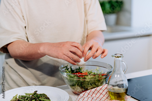 woman cooking a healthy diet vegetable salad with tomatoes, mozzarella cheese, green salad, olive oil and balsamic