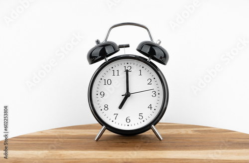 Black alarm clock on grey wall background