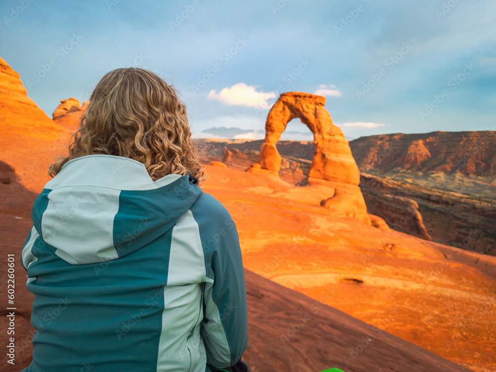 Φωτογραφία woman oberserving sunset delicate arch in arches national park in utah usa