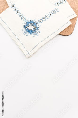 immagine con primo piano di tovaglioli in cotone ricamato su superficie tavolo bianca photo