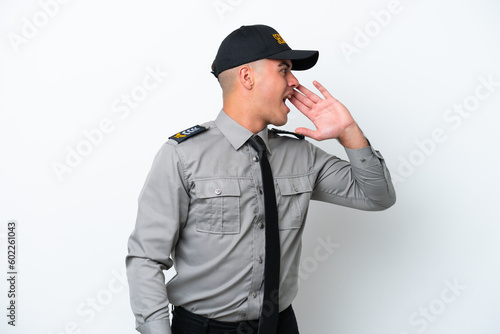 Young caucasian security man isolated on white background shouting with mouth wide open to the lateral