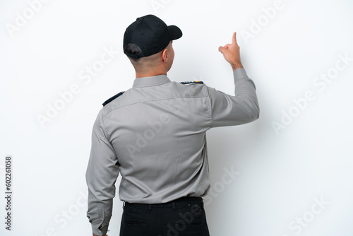 Young caucasian security man isolated on white background pointing back with the index finger © luismolinero