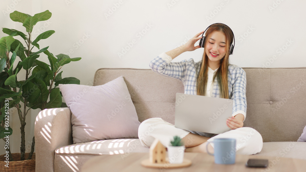 Rest time concept, Women sitting on comfortable couch and wearing headphone to watching movie