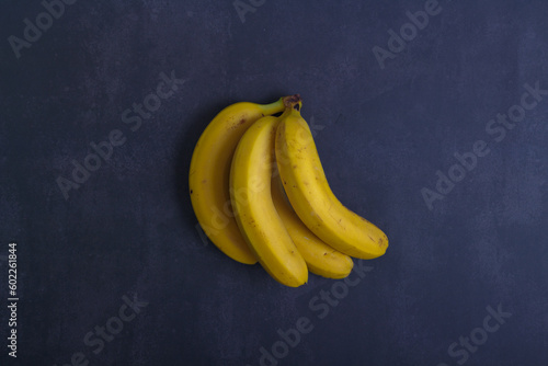 Bunch of bananas on blue dark background. Top view . Copy space