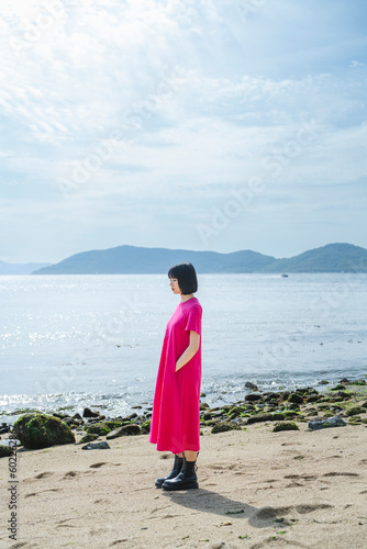 晴天の海を散策する女性