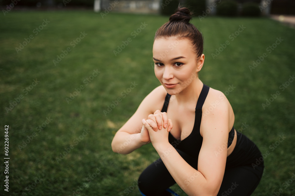 Fitness woman doing squats with rubber bands on her legs Fitness woman doing squats with rubber bands on her legs