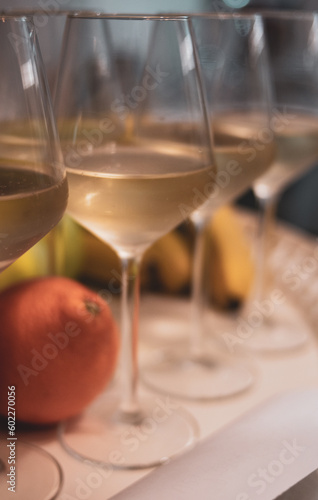 glasses of white wine on table next to fruit