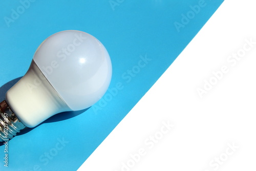 Fotografia An economical white lamp lies on a blue background.