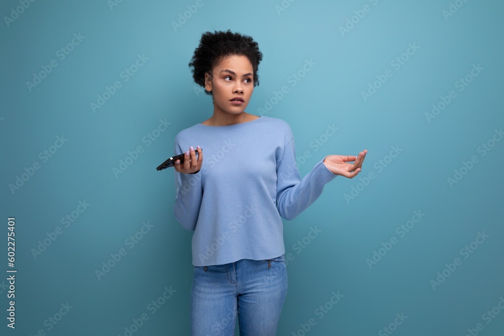 confused young brunette woman with afro curls throws up her hands confused young brunette woman with afro curls throws up her hands