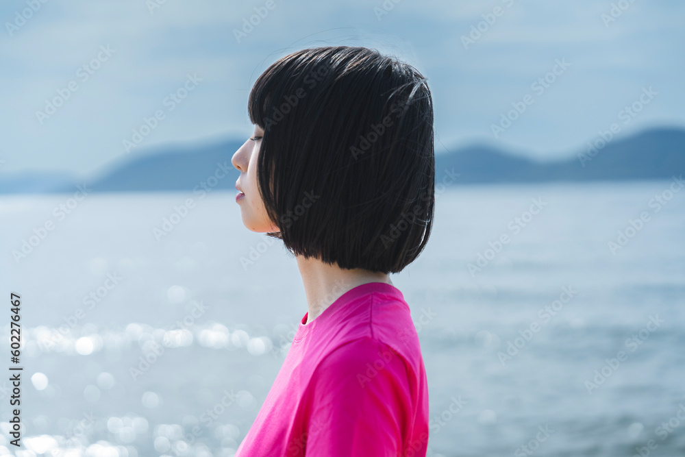 晴天の海を散策する女性