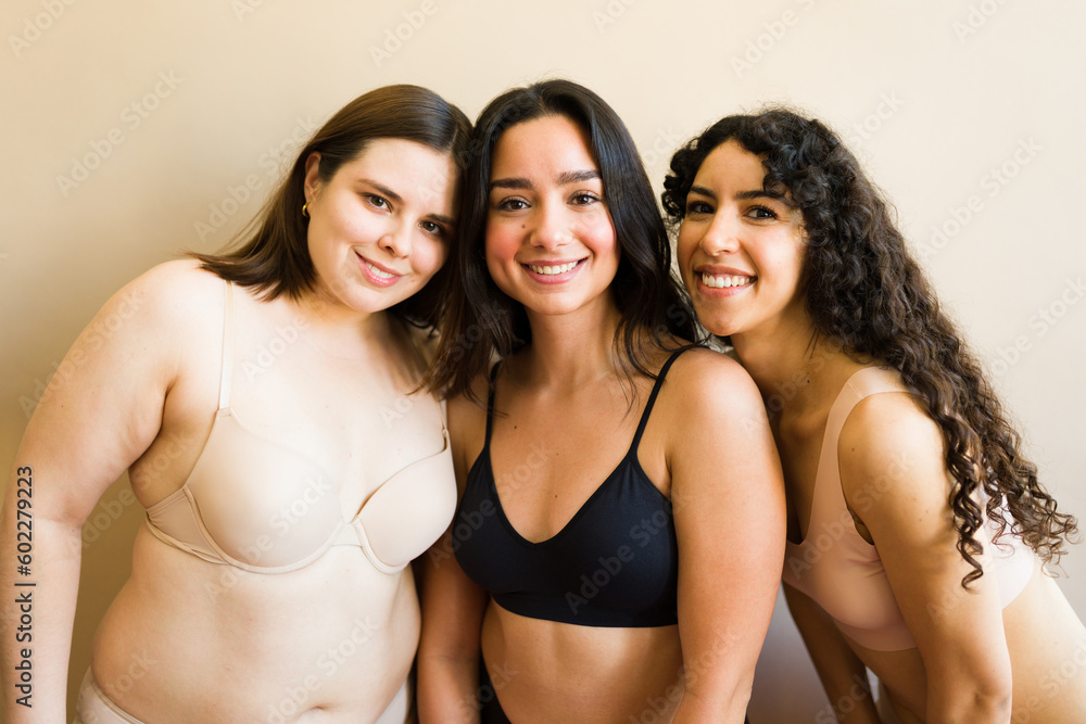Happy female friends in underwear smiling with a lot of self love Happy female friends in underwear smiling with a lot of self love
