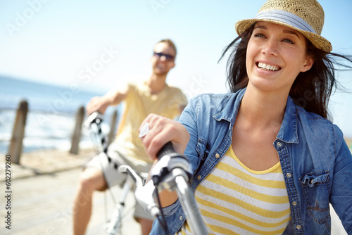 Canvastavla Bike, cycling and couple with a travel woman on summer vacation or holiday riding on the promenade by the beach