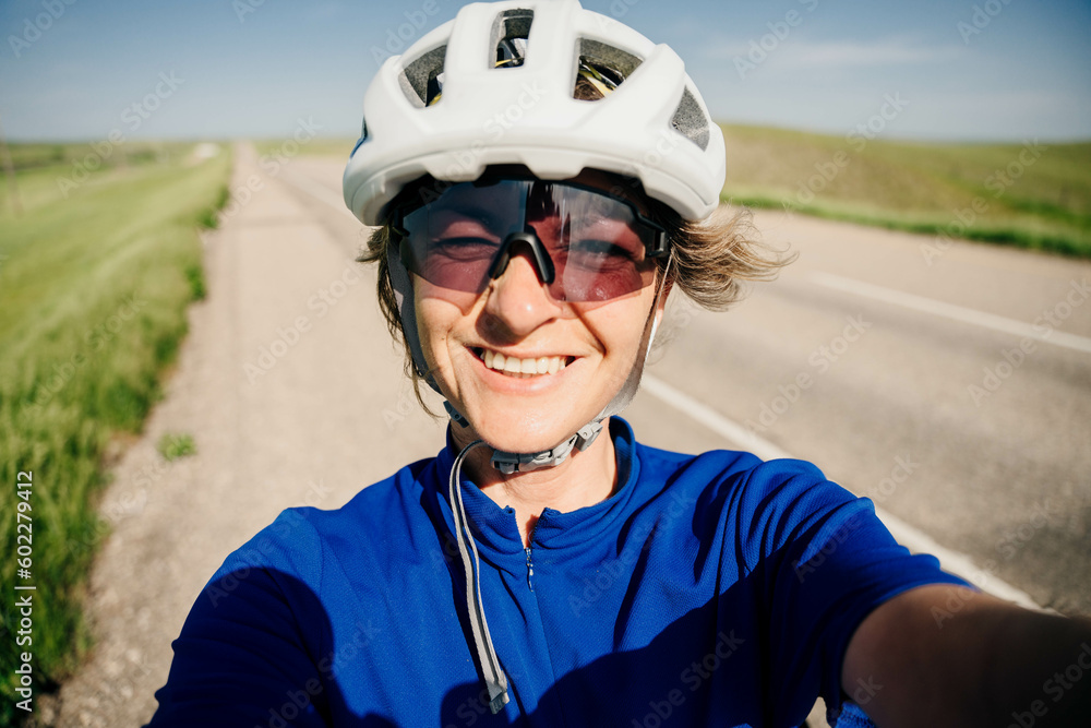 cyclist in a white helmet takes a selfie and smiles cyclist in a white helmet takes a selfie and smiles