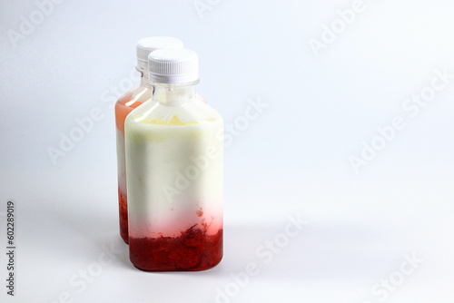 Bottles of home made fruit drinking yogurt, selective focus on white background
