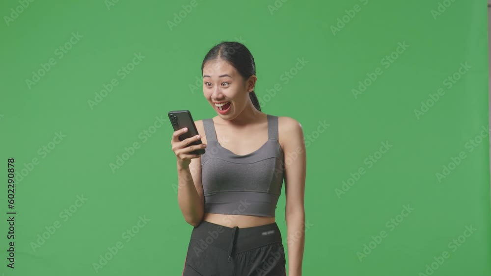 Asian Woman Wearing Sportswear And Looking At Smartphone Then Saying Wow On Green Screen Background In The Studio
Asian Woman Wearing Sportswear And Looking At Smartphone Then Saying Wow On Green Screen Background In The Studio