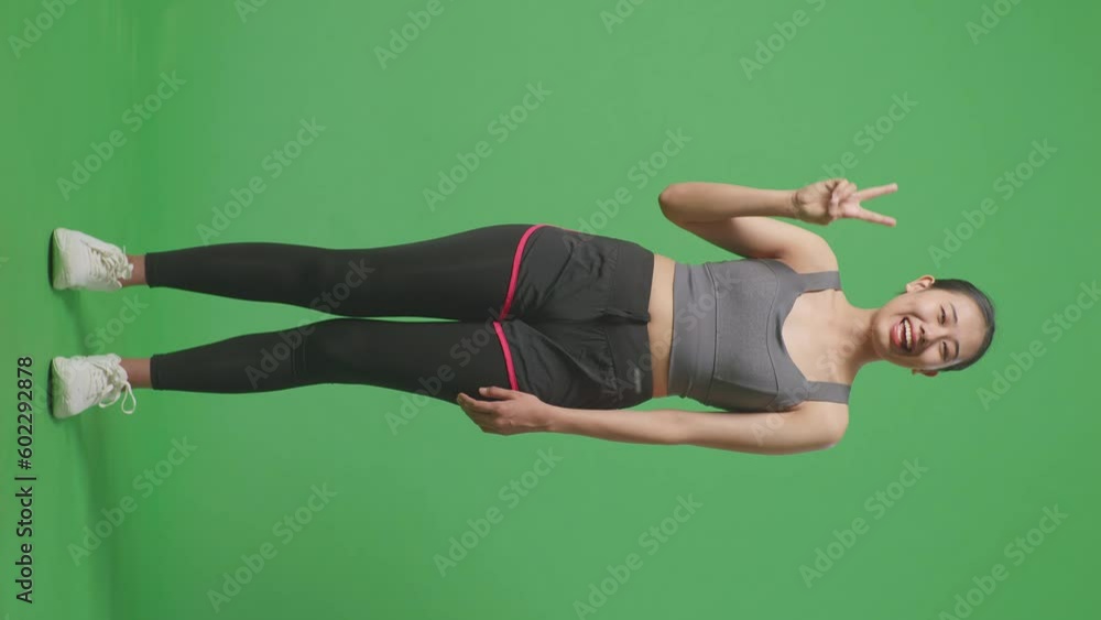 Full Body Of Asian Woman Wearing Sportswear And Showing Peace Gesture And Smiling To Camera On Green Screen Background In The Studio
Full Body Of Asian Woman Wearing Sportswear And Showing Peace Gesture And Smiling To Camera On Green Screen Background In The Studio